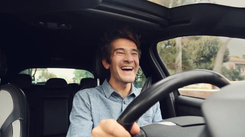 Happy ecstatic man driving car