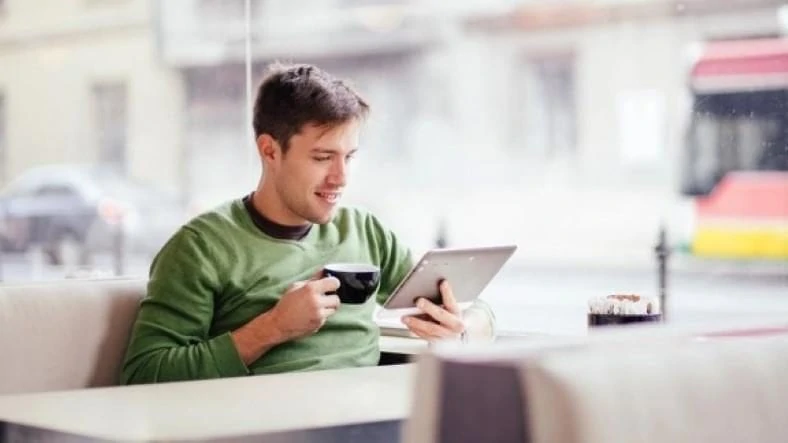Image of man casually shopping online with a tablet